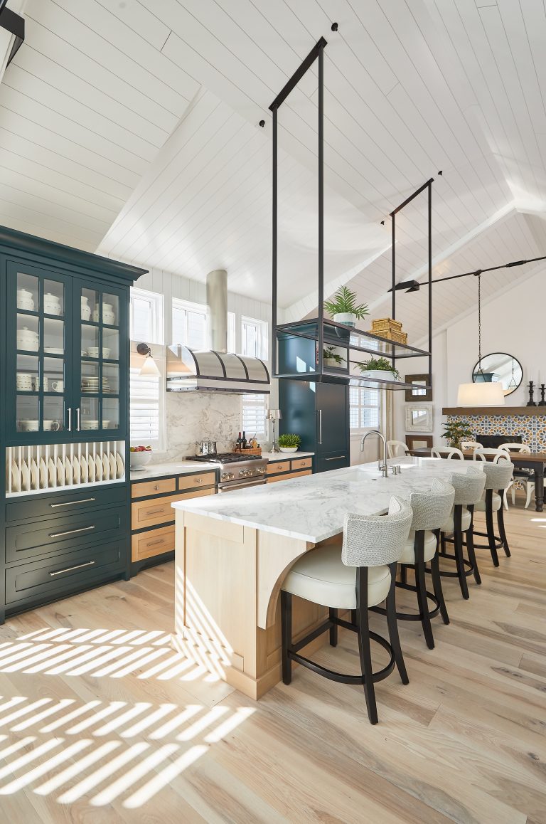 A spacious kitchen featuring a large island, elegant wooden floors, and stylish cabinetry and furniture. Contact Miller Cabinetry to start your project today!