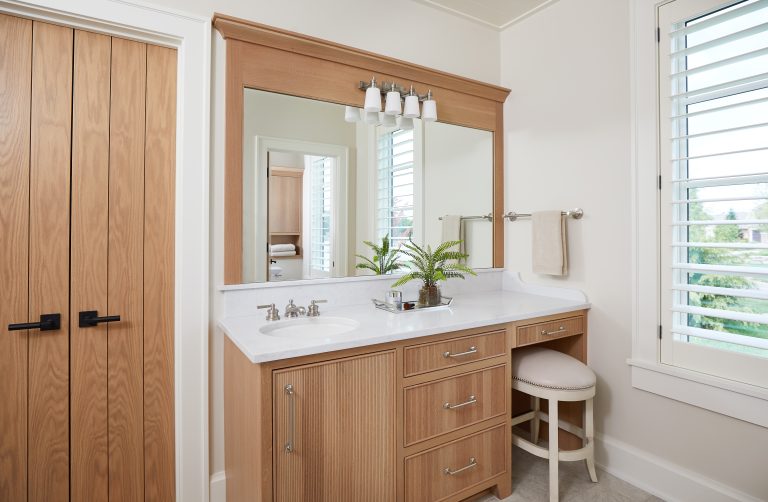 A stylish bathroom featuring a vanity and mirror, part of the Bathroom Collections by Miller Cabinetry.