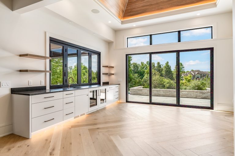 Beautiful cabinets with baseboard lights in an open area with large windows are showcased in the custom cabinet projects gallery